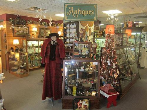 A cozy antique shop filled with vintage items, displays, and a decorated Christmas tree.