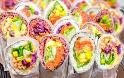 A colorful assortment of sushi rolls wrapped in rice and seaweed, filled with vegetables and seafood.