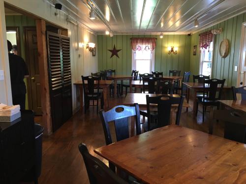 Cozy restaurant interior with wooden tables, green walls, and warm lighting, featuring a star decoration and checkered curtains.