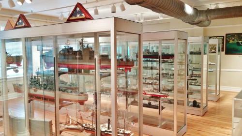 Display cases filled with detailed ship models in a well-lit museum setting.