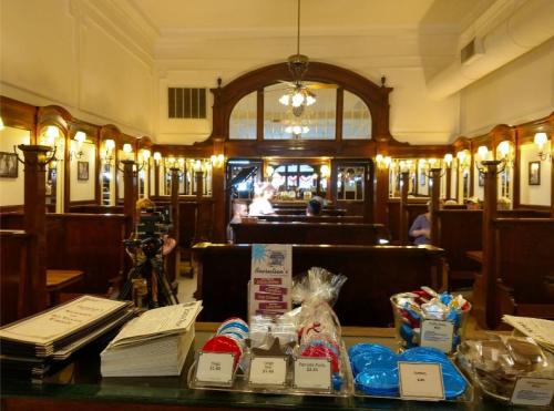A cozy restaurant interior with wooden decor, tables, and a display of sweets in the foreground.