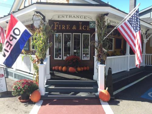 Entrance to "Fire & Ice" restaurant, decorated with pumpkins, flowers, and flags, welcoming visitors.