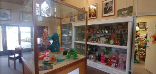 A display room filled with colorful toys and collectibles, featuring glass cases and shelves of various items.