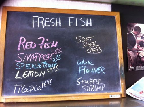 Chalkboard menu listing fresh fish options: Red Fish, Snapper, Speckled Trout, Lemon, Tilapia, Soft Shell Crab, Whole Flounder, Stuffed Shrimp.