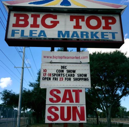 Sign for Big Top Flea Market featuring upcoming events: coin show, sports card show, and shopping hours.