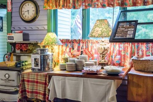 A cozy dining area with a table set with plates, a lamp, and decorative curtains, creating a warm atmosphere.