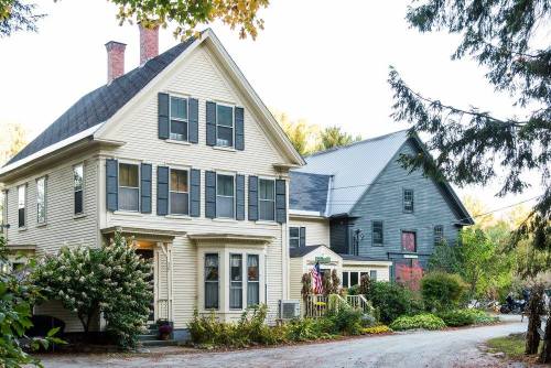 Two large, historic houses with distinct architectural styles, surrounded by trees and autumn foliage.