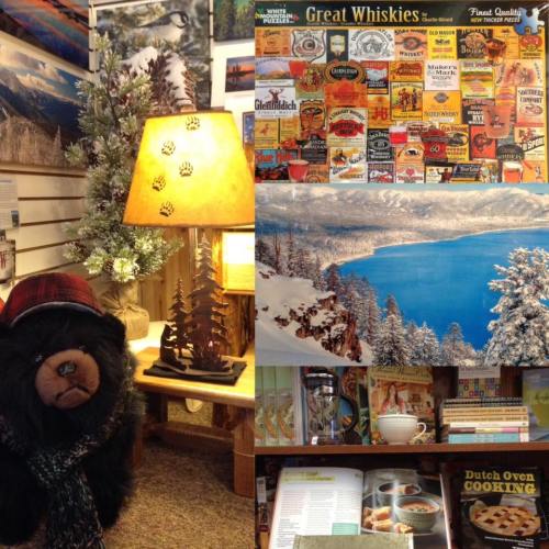 A cozy shop interior featuring a bear statue, a lamp, a whiskey display, and shelves of cookbooks and decor.