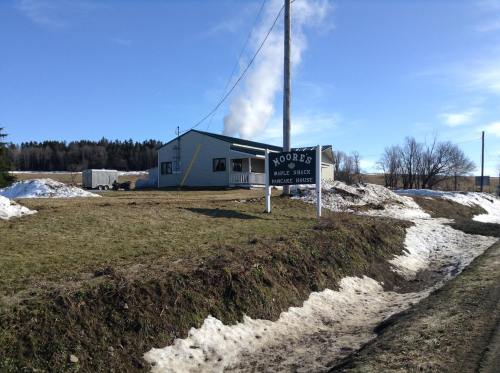 A pancake house named Moore's Maple Shack, with snow on the ground and smoke rising in the background.