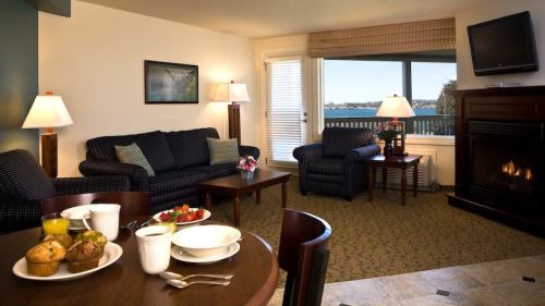 Cozy hotel room with a view, featuring a seating area, fireplace, and a breakfast table with muffins and fruit.