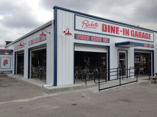 Exterior of Parkette Dine-In Garage, featuring a blue and white building with signage for burgers, chicken, and fish.