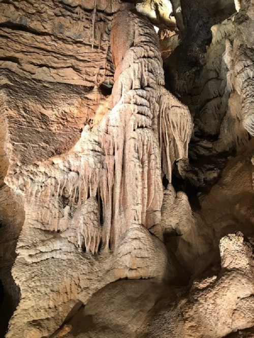Stalactites and stalagmites in a cave, showcasing intricate rock formations and textures.