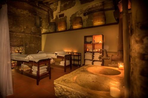 A serene spa room with massage tables, soft lighting, and a stone sink, creating a calming atmosphere.