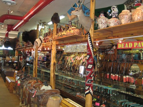 A rustic store interior filled with Western-themed decor, saddles, and various handcrafted items on display.