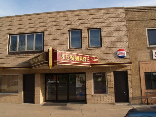 Exterior of the Kenmare theater building, featuring a marquee and large glass entrance, with a brick facade.