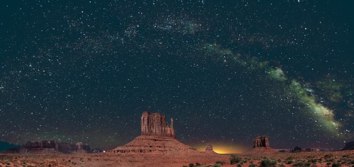 A stunning night sky filled with stars and the Milky Way over Monument Valley's iconic rock formations.