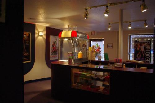 A cozy concession stand with a popcorn machine, candy displays, and colorful posters on the walls.