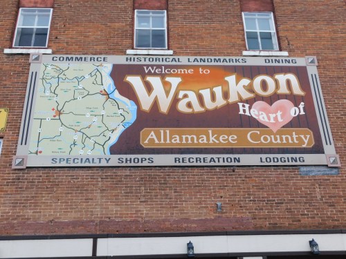 Sign welcoming visitors to Waukon, highlighting its historical landmarks and attractions in Allamakee County.