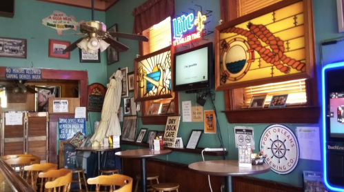 Cozy interior of a bar with stained glass, wooden tables, and vintage decor, creating a warm, inviting atmosphere.