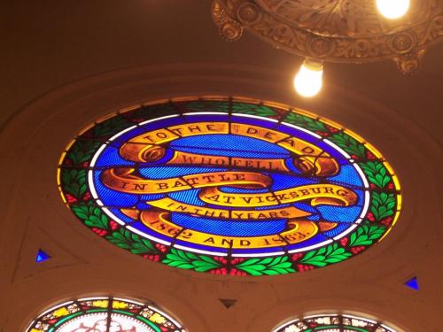 Stained glass memorial window honoring those who died in the Battle of Vicksburg, featuring vibrant colors and inscriptions.