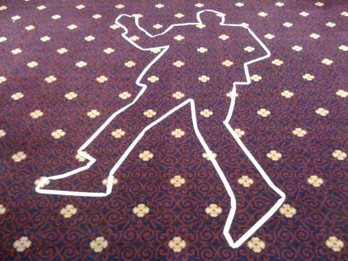 Outline of a person on a patterned carpet, resembling a crime scene investigation marker.