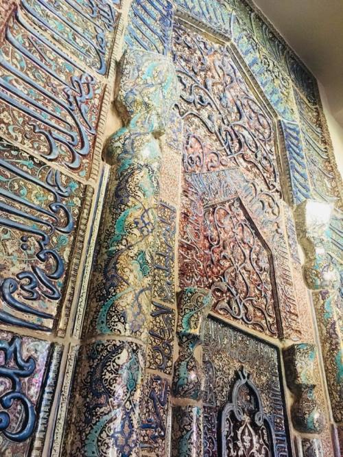 Intricate wall decoration featuring colorful patterns and calligraphy, showcasing ornate Islamic art and design.
