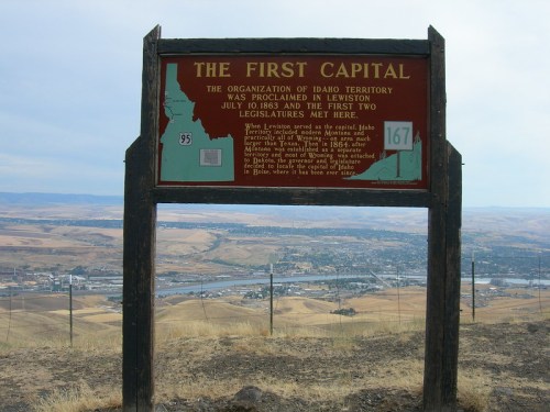 Sign marking the site of Idaho's first capital in Lewiston, with a view of the surrounding landscape.