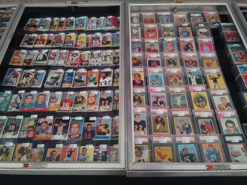 A display case filled with various sports trading cards, organized by player and team, showcasing colorful designs.