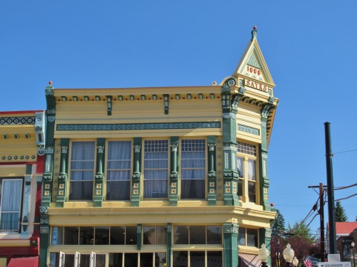 Historic building with colorful architecture, featuring large windows and decorative details against a clear blue sky.