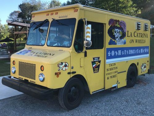 A bright yellow food truck named "La Catrina on Wheels," featuring colorful graphics and a menu of tacos and burritos.