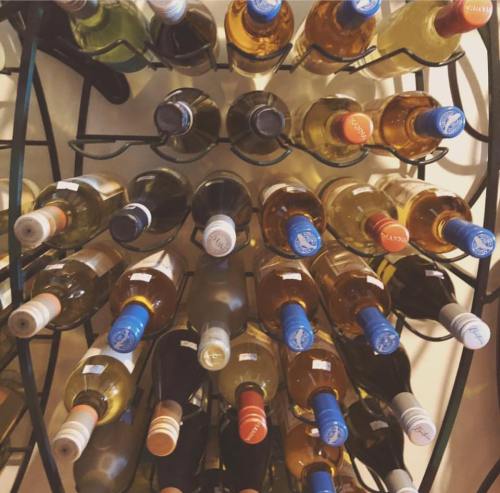 A circular wine rack filled with various bottles of white and red wine, showcasing different labels and colors.