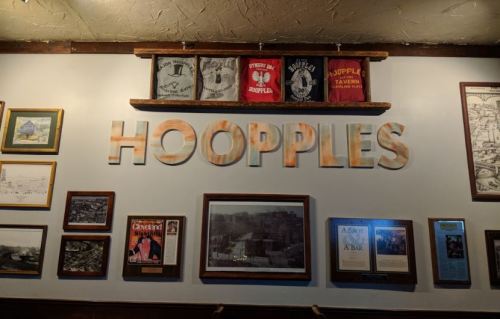 A wall display featuring the word "HOOPPLES" and various framed pictures and memorabilia.