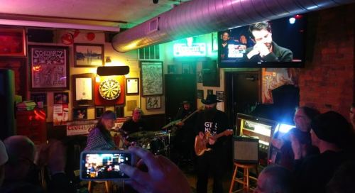 A lively bar scene with a band performing on stage, surrounded by patrons enjoying the music and atmosphere.