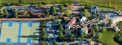 Aerial view of a recreational area featuring sports courts, playgrounds, and landscaped pathways.