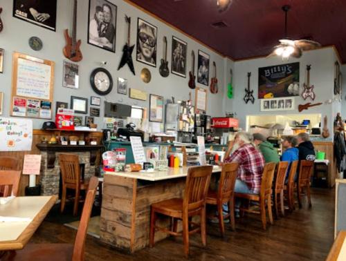 A cozy diner interior with wooden tables, guitars on the walls, and patrons enjoying their meals.