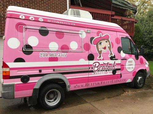 A pink food truck with polka dots and a cartoon logo, promoting "Beatnik's Sweet Eats."