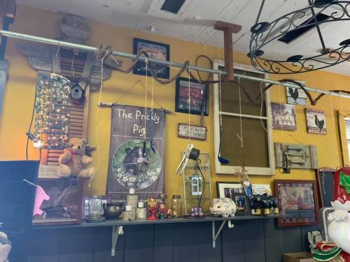 A colorful wall display featuring various vintage items, signs, and decorations in a cozy shop setting.