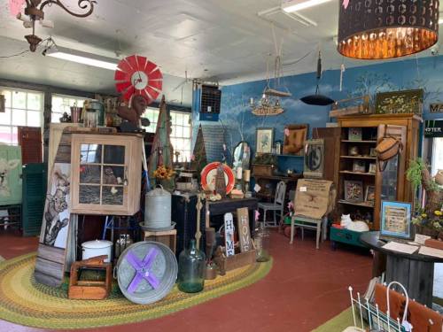 A cozy antique shop filled with vintage decor, furniture, and unique items, featuring colorful displays and rustic charm.