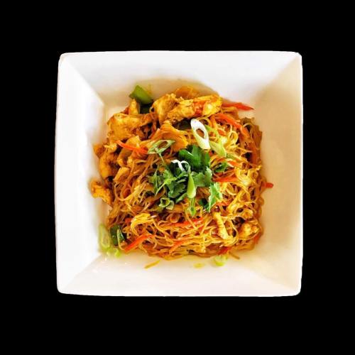A square white plate filled with stir-fried noodles, chicken, and colorful vegetables, garnished with green onions and cilantro.