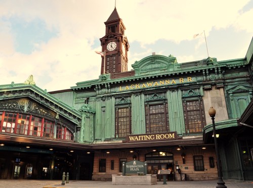 Historic Lackawanna Railroad station with a clock tower and green copper accents, featuring a waiting room sign.
