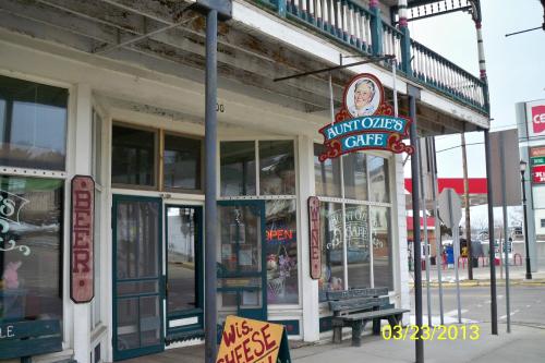 Exterior of Aunt Ozie's Cafe with a sign, featuring a vintage storefront and nearby signage for beer and cheese.