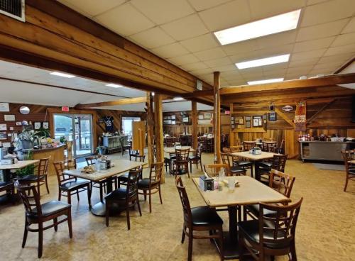 Interior of a rustic restaurant with wooden beams, tables, and chairs, featuring a cozy, inviting atmosphere.