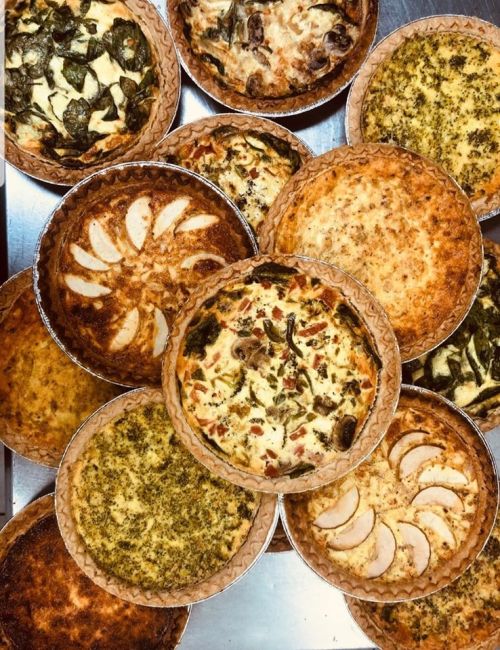A variety of freshly baked pies arranged on a table, showcasing different toppings and crusts.