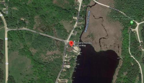 Aerial view of Benson's Holiday Hide-A-Way near Watercress Creek, surrounded by trees and water.
