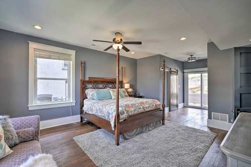Spacious bedroom with a four-poster bed, cozy seating area, and large windows letting in natural light.