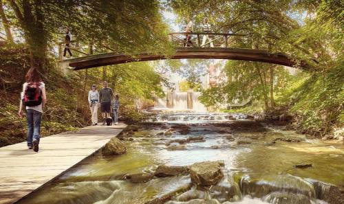 A serene scene of a wooden bridge over a stream, with people walking along a path surrounded by lush greenery.