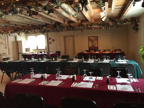 A cozy dining room with tables set for a meal, adorned with festive decorations and soft lighting.