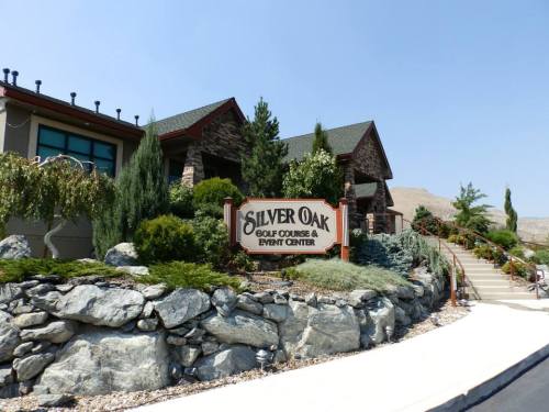 Sign for Silver Oak Golf Course & Event Center, surrounded by greenery and stone landscaping.