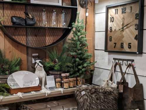 A cozy display featuring a small tree, decorative items, a clock, and rustic decor in a warm, inviting setting.