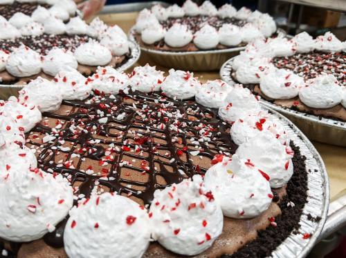 A close-up of decorated desserts with whipped cream and red sprinkles on a table.